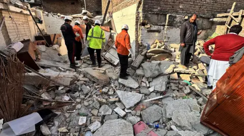 EPA Residents and rescue workers search rubble after a gas cylinder blast in Islamabad, Pakistan, 11 January 2026.
