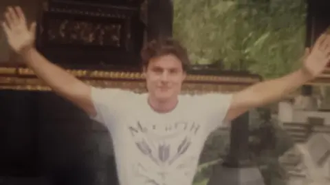 Supplied Matthew Osborne is pictured in a grainy image. He has his arms outstretched and is wearing a white t-shirt.