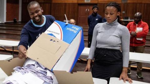 Electoral Commission of South Africa (IEC) officials empty a ballot box during the vote counting process at the Norwood school voting station in Durban on May 29, 2024, during South Africa's general election