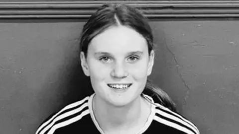 PA Media Black and white picture of Holly Newton with long hair in a pony tail