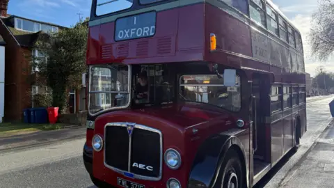 A large vintage red bus stopped.