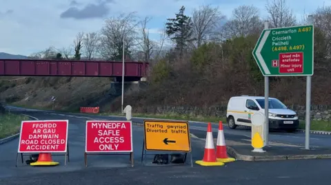 Road closed after crash. Road blocked by signs and cones.