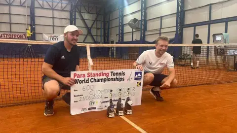Matt Grover Ross Cudmore and Matt Grover with a banner and trophy after winning the 2024 world championships 