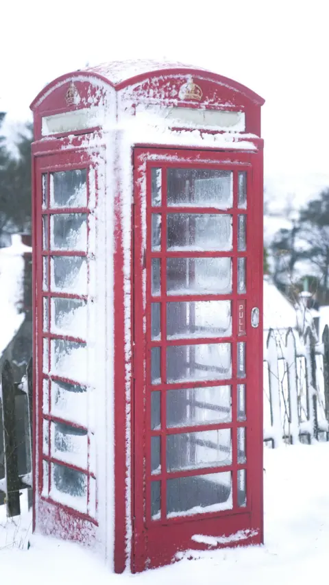 PA Media Snow on a phone box