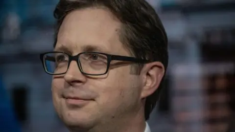 Getty Images The Conservative MP Alex Burghart smiling and looking sideways during a television interview

