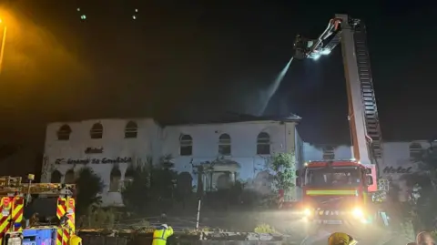 Derbyshire Fire and Rescue Service Fire crews hosing down after the fire at La Gondola