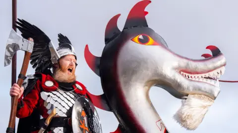 PA Media Lynden Nicolson, the Guizer Jarl of the Jarl Squad on the galley. He is in Viking gear and shouting