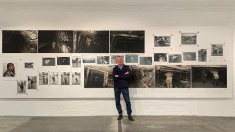 Ian Beesley in front of his photographs