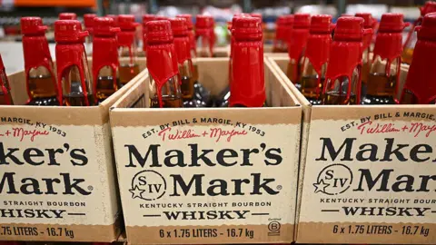 Getty Images Bottles of Makers Mark Kentucky Bourbon are displayed for sale at a Costco Wholesale warehouse store. The bottles have a red wax seal, and are stored in carton boxes that feature the Maker's Mark logo.