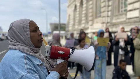 BBC Amina Ismail addressing the crowd with a megaphone