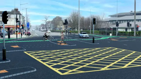 Hull City Council An artist's impression of how the new cycle friendly junction at Blundell's Corner could look. There is a box junction marked with yellow lines. There are cycle lanes and dropped kerbs for pedestrians at a cross roads with traffic signals.