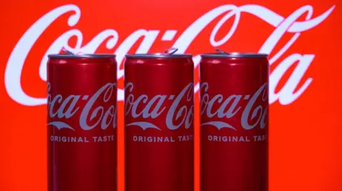 Cans of Coca-cola against a red backdrop