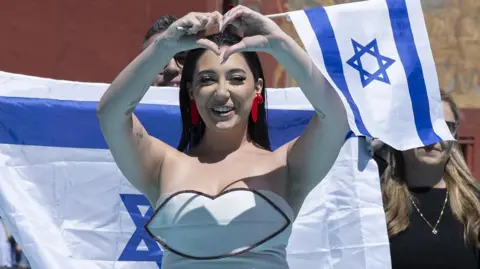 Israel's Yuval Raphael posing on the turquoise carpet during the opening ceremony of the 69th Eurovision Song Contest in Basel, Switzerland