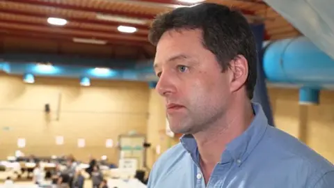 Lib Dem MP Chris Coghlan giving an interview in a sports hall