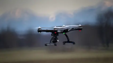 Getty Images A drone in flight, over a rural location