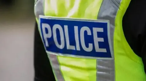 A generic yellow police jacket with the word "police" printed in white on a blue background