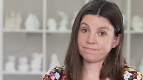 Jamie Niblock/BBC A head and shoulders image of Sam Murray. She is wearing a floral top and tilting her head slightly. She is looking directly into the camera. 
