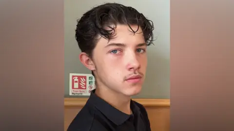 Cambridgeshire Police Declan Berry looks into the camera and has dark wavy hair and is wearing a black polo shirt