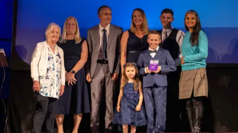 Hollie Benson and her family and friends on stage