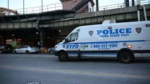 Getty Images A white NYPD van is parked outside a Brooklyn station where a woman died after being set on fire