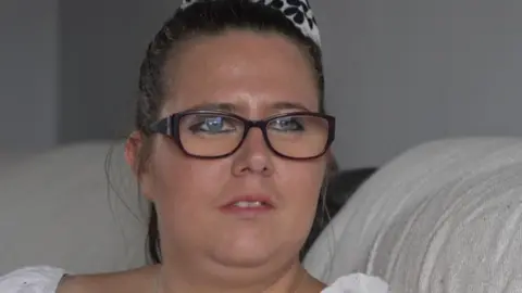 A woman in a white shirt with rectangular glasses