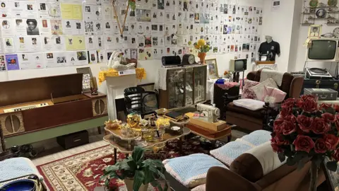 Jon Wright/BBC The Reflection Room. It looks like a living room with memorabilia from across the years.