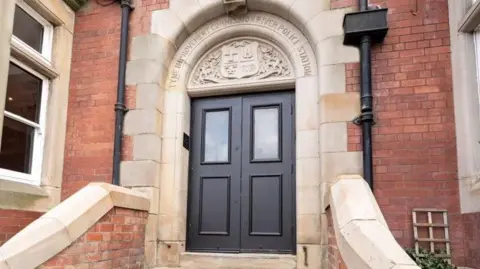 Bella Welsh The door to the venue with an inscription above it which reads Tyne Improvement Commission River Police Station. It is a brick built building with an ornate door 