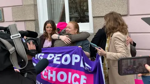Assisted dying campaigners hugging after Jersey's bill was passed outside the States chamber.