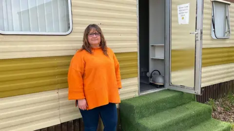 bbc Lady standing outside a static caravan