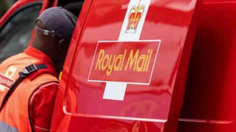 Getty Images Royal Mail worker looking at their van
