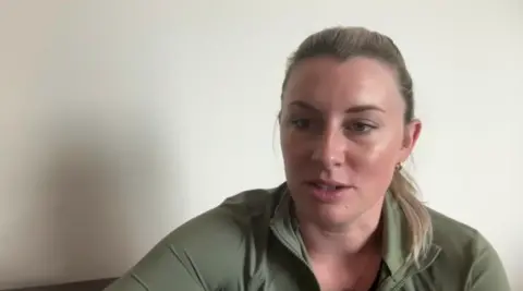 BBC Christi Hill wears a green sweater as she speaks 