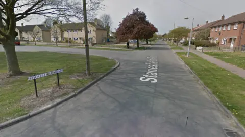 A google street view of Stanesfield Road in Cambridge. The road is a residential area with houses on either side of the street.