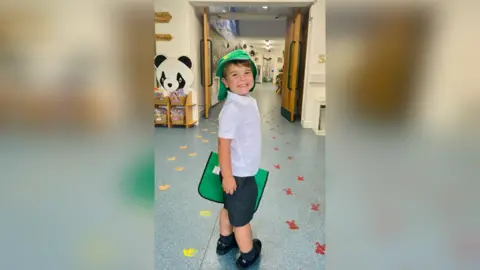 Family photo A young boy smiles in a school corridor