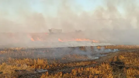Shropshire Fire and Rescue Service A burning field with flames seen in the distance