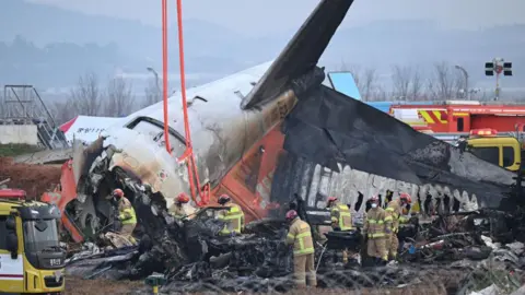 Firefighters and recovery teams work at the scene where a Jeju Air Boeing 737-800 series aircraft crashed and burst into flames at Muan International Airport in Muan, some 288 kilometres southwest of Seoul on December 30, 2024