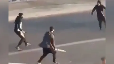 Three men carrying machetes in the street in Southend.