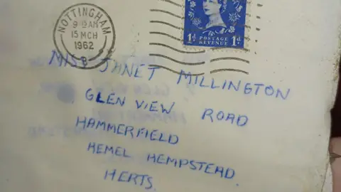 A letter with a Nottingham post stamp dated 15th March 1962. It is addressed in blue ink to a woman in Hemel Hempstead. The stamp is blue and has a picture of  Queen Elizabeth II