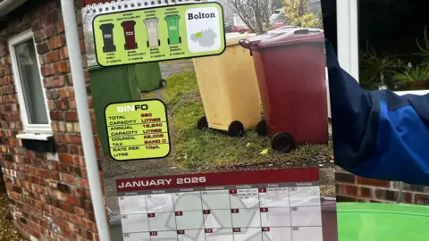 The calendar showing January 2026 with a photograph of Bolton's green, beige and burgundy bins