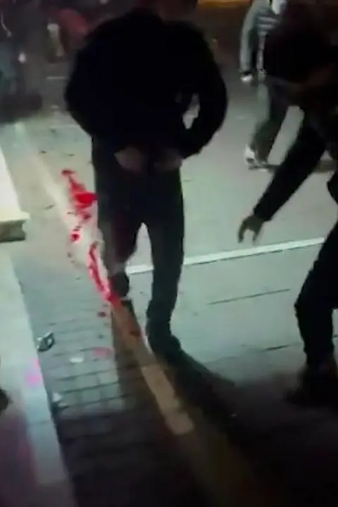 Imanemunmusic/X Screengrab from a video showing wounded people fleeing the sound of gunfire at a protest in eastern Tehran