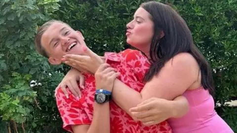 Dolan family Jack with his mum, who is leaning in to kiss him