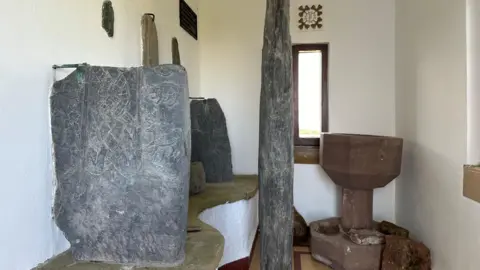 Manx Stone crosses standing upright in the church at Jurby. The stone slabs feature Viking and other carvings.