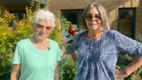 Two residents enjoy the communal garden 