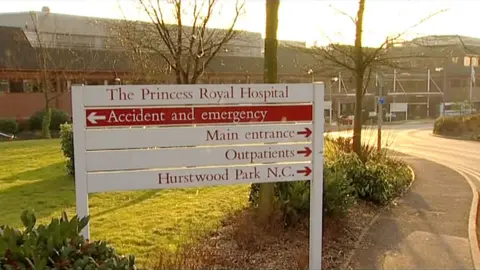BBC South East Today A hospital sign on a grass verge directing traffic to various departments within the hospital grounds