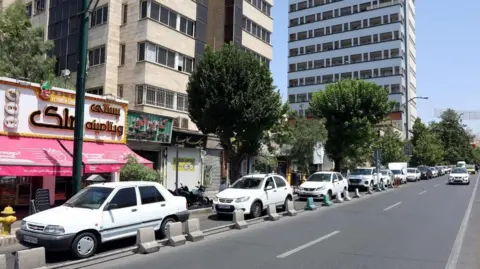 EPA-EFE Iranians queue with their vehicles near a petrol station following Israeli strikes on Iran, in Tehran, 15 June 2025.

