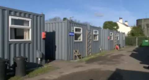 BBC Four navy blue corrugated iron shipping containers with windows. 