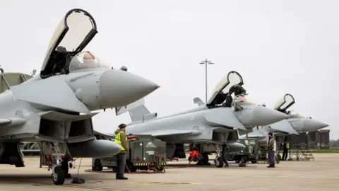 Three RAF Typhoon aircraft, with their canopies open, prepare to depart RAF Coningsby for Qatar