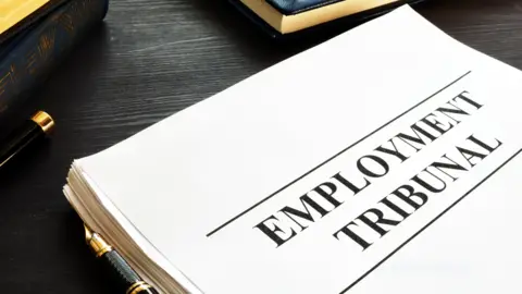 Getty Images An image showing a thick stack of white paper on which the words Employment Tribunal are written. A black and gold pen can also be seen in shot.