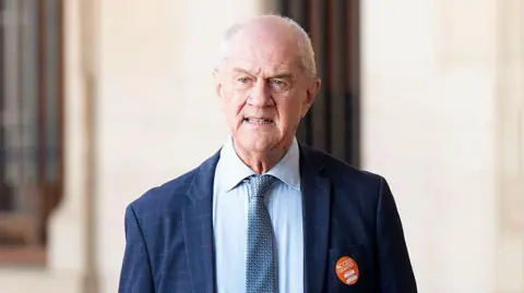 Roelf Meyer is seen in a blue suit and tie as he stands outside the Union Buildings