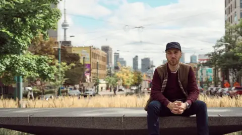 Matteo Sgaramella Matteo Sgaramella sits on a concrete slab with the skyline of Toronto in the background