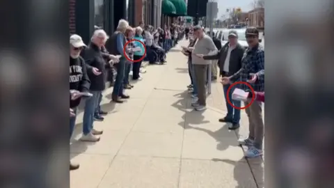 People form two lines of human chain and pass books.